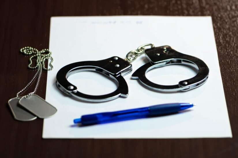 Cuffs A photo of cuffs with a pen and paper and dog tags